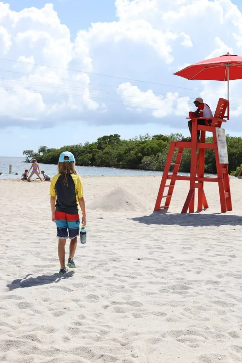 boy walks on beach cruise destination