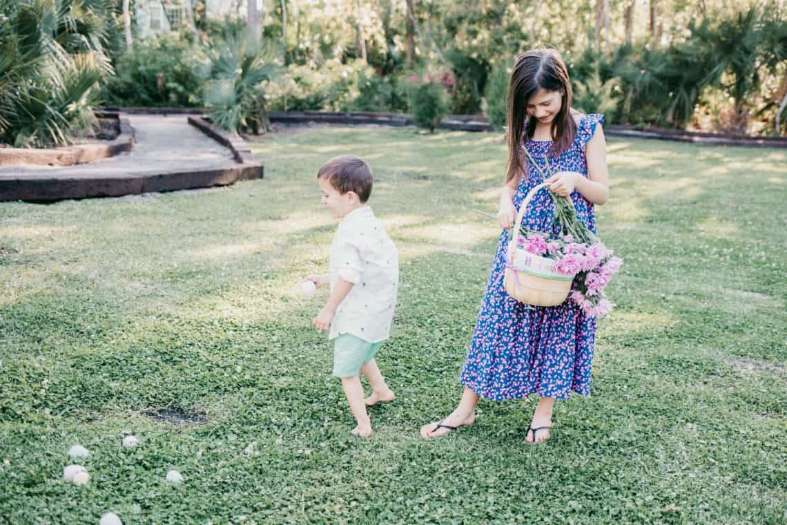 Kids collecting easter eggs on the lawns wearing kids easter outfits.