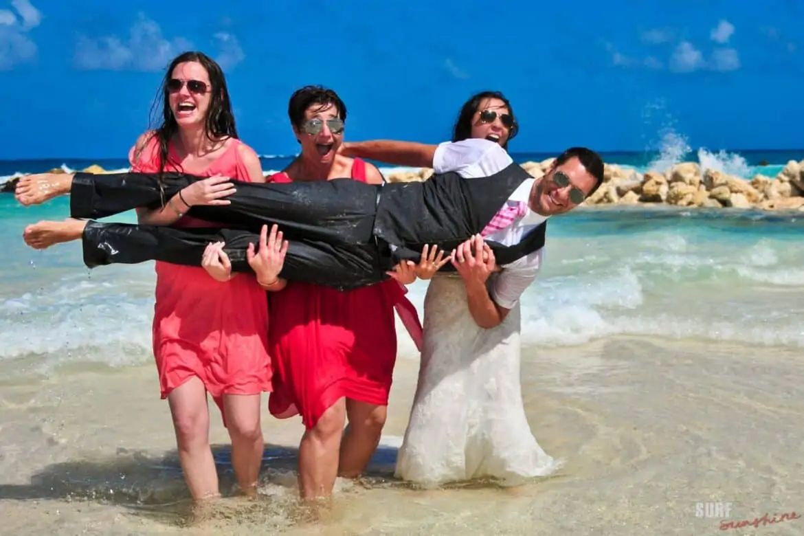 beach  trash the dress bride and bridesmaids holding groom fun photo idea