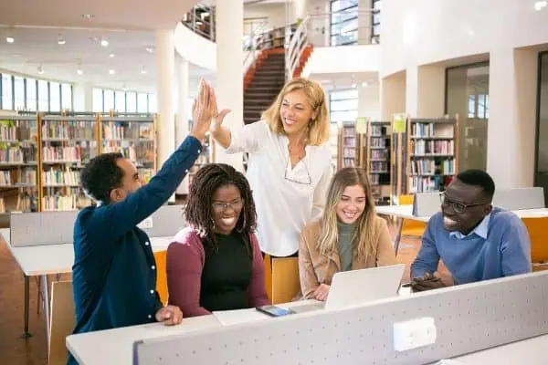 teacher giving a high five to a student in a library