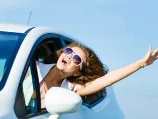 happy girl out car window