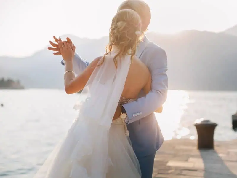 wedding couple dance at sunset by water