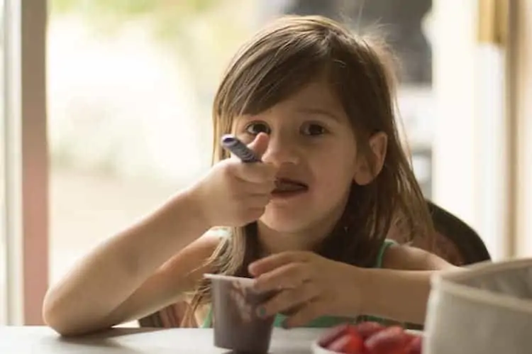 girl eating chocolate pudding